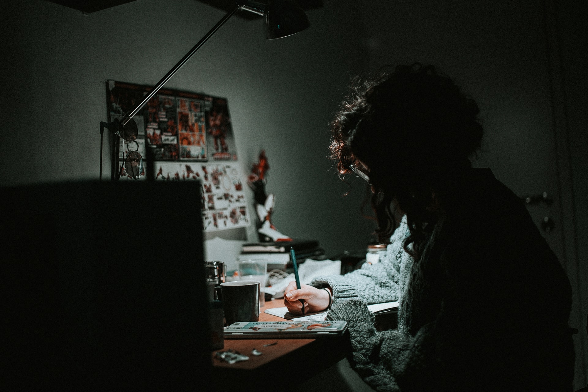 Fille qui prend des notes devant une lampe de bureau