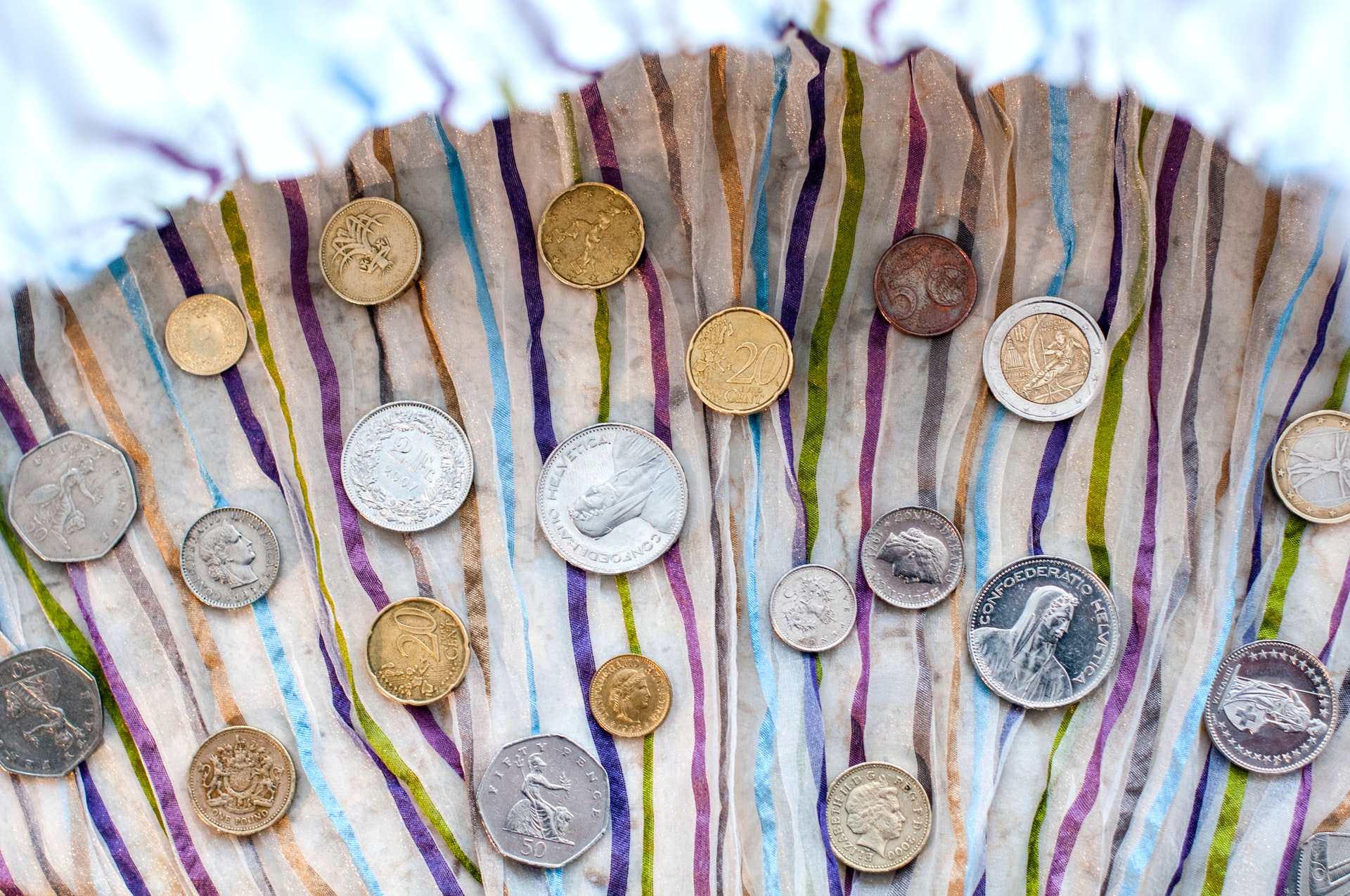 différentes pièces de monnaie sur un tissu coloré