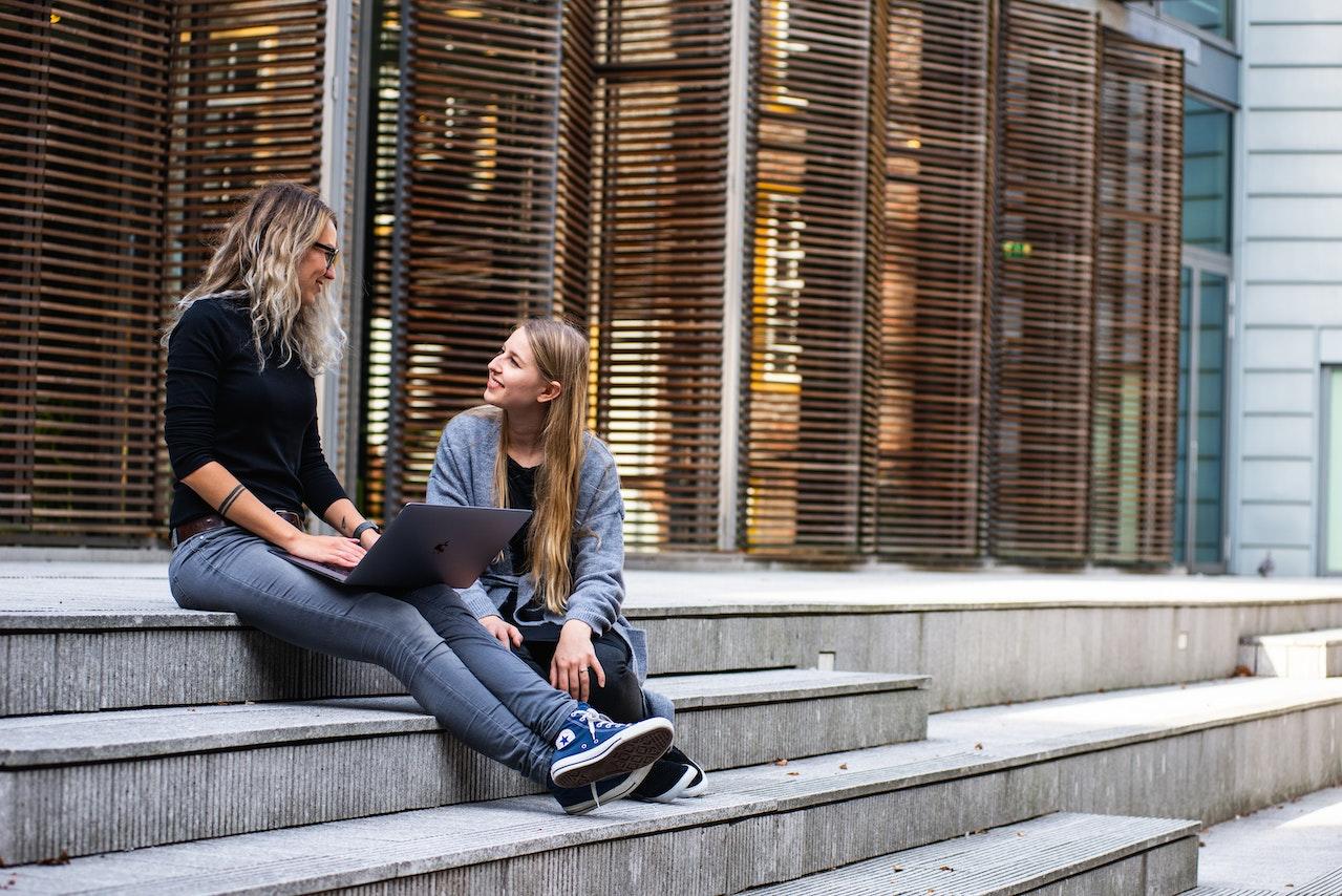 deux jeunes femmes discutant sur les marches de l universite