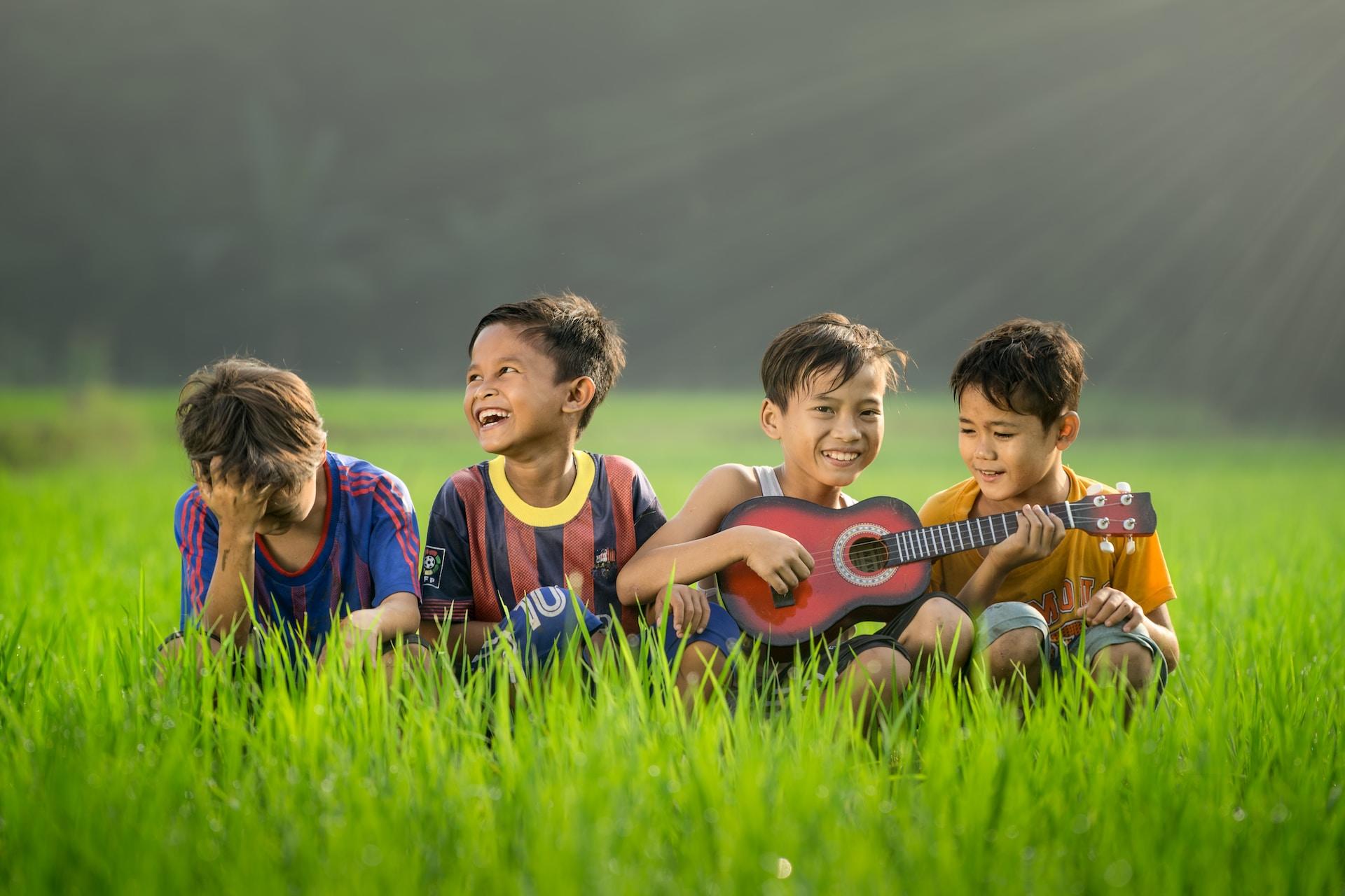 Des enfants et une guitare à l'extérieur.