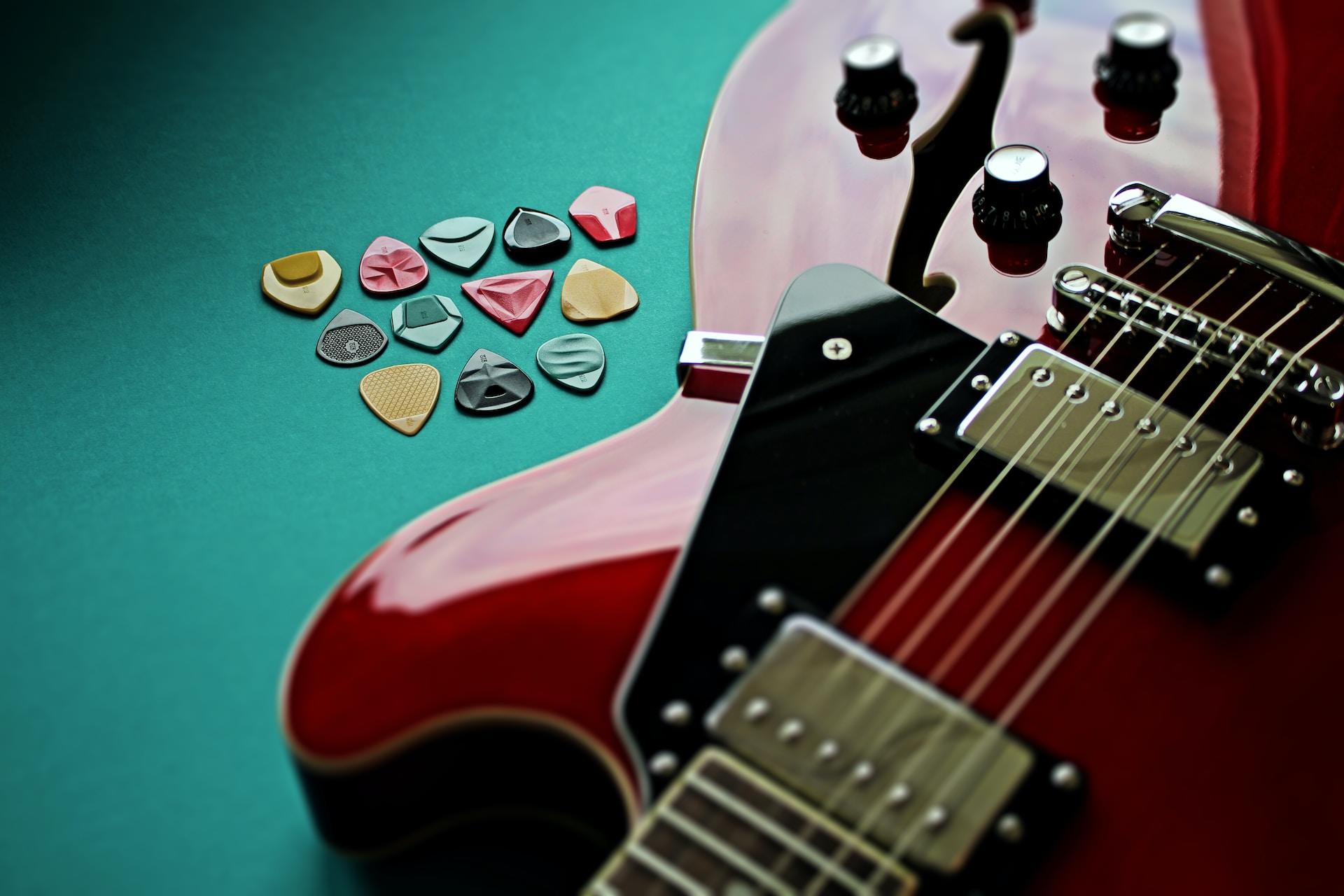 Une guitare et des médiators de couleurs différentes.