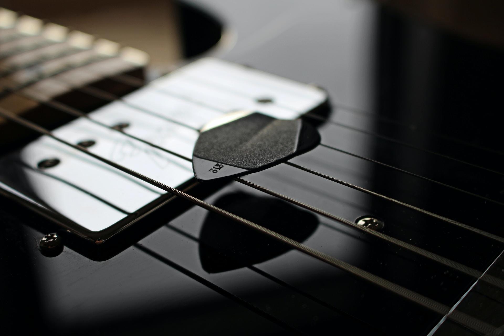 Médiator noir sur une guitare noire.