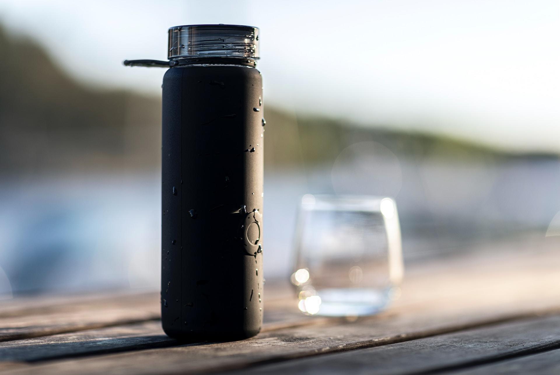 bouteille noire thermos avec eau dedans