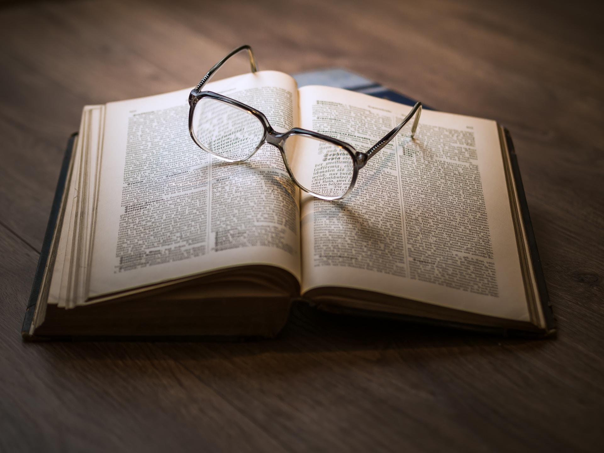livre avec écriture ancienne et lunettes