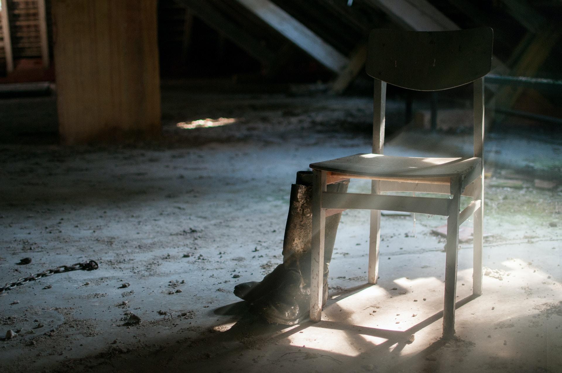chaise et bottes dans une pièce isolée sale