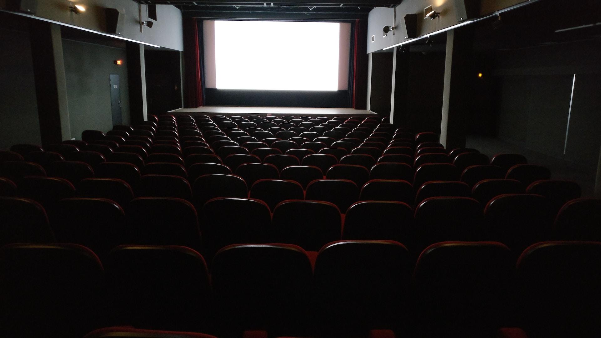 salle de cinéma avec grand écran plongée dans le noir