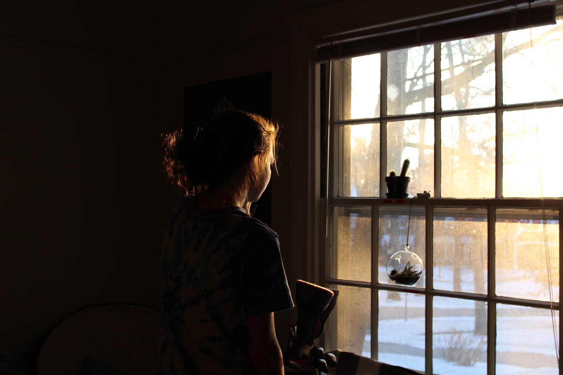 jeune femme face à la buée d'une fenêtre