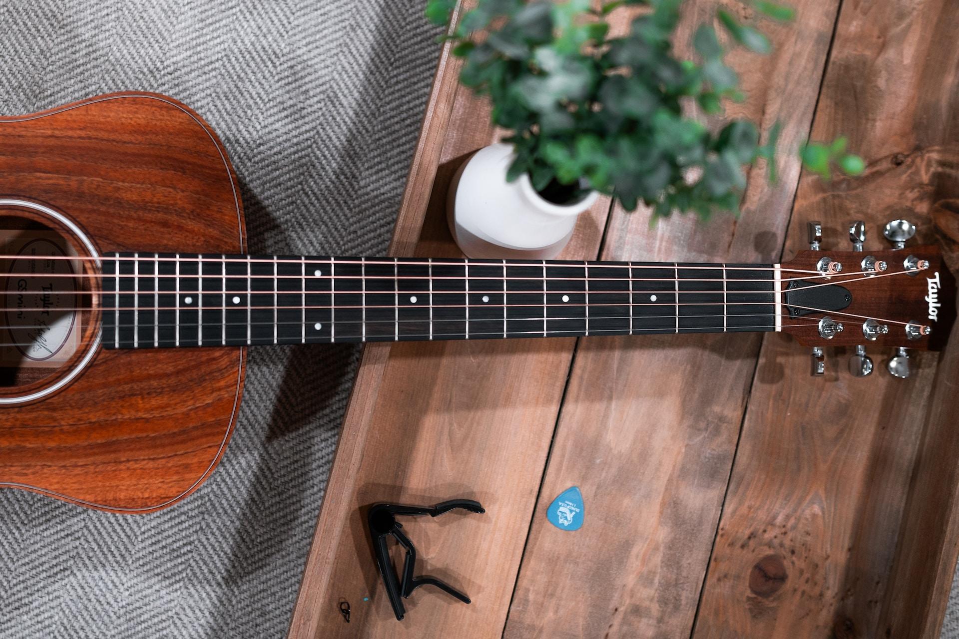 capo posé sur une table en bois près de la guitare