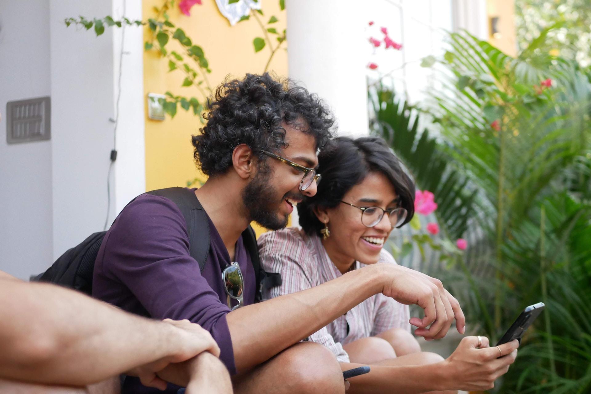 Deux personnes qui regardent un téléphone.