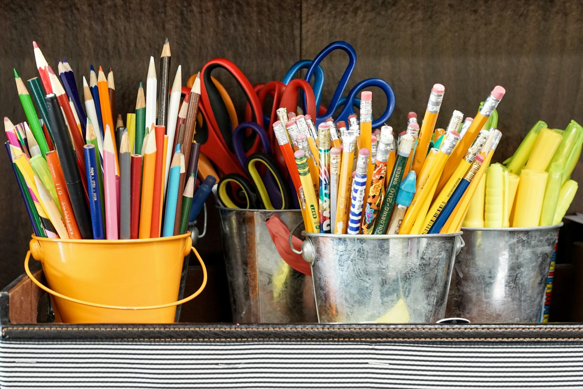 Crayons et ciseaux dans des pots.