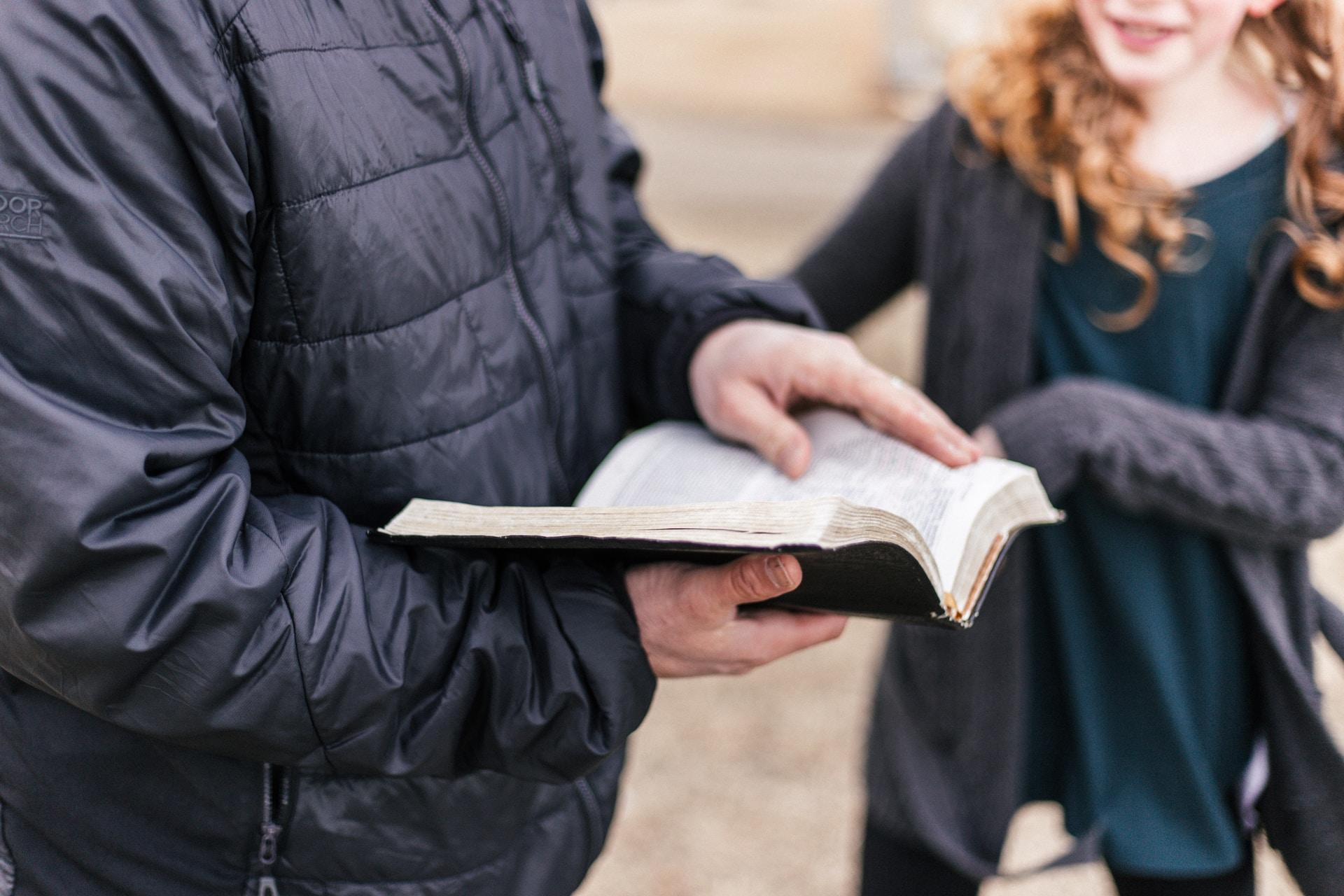 Two personnes debouts et un livre.