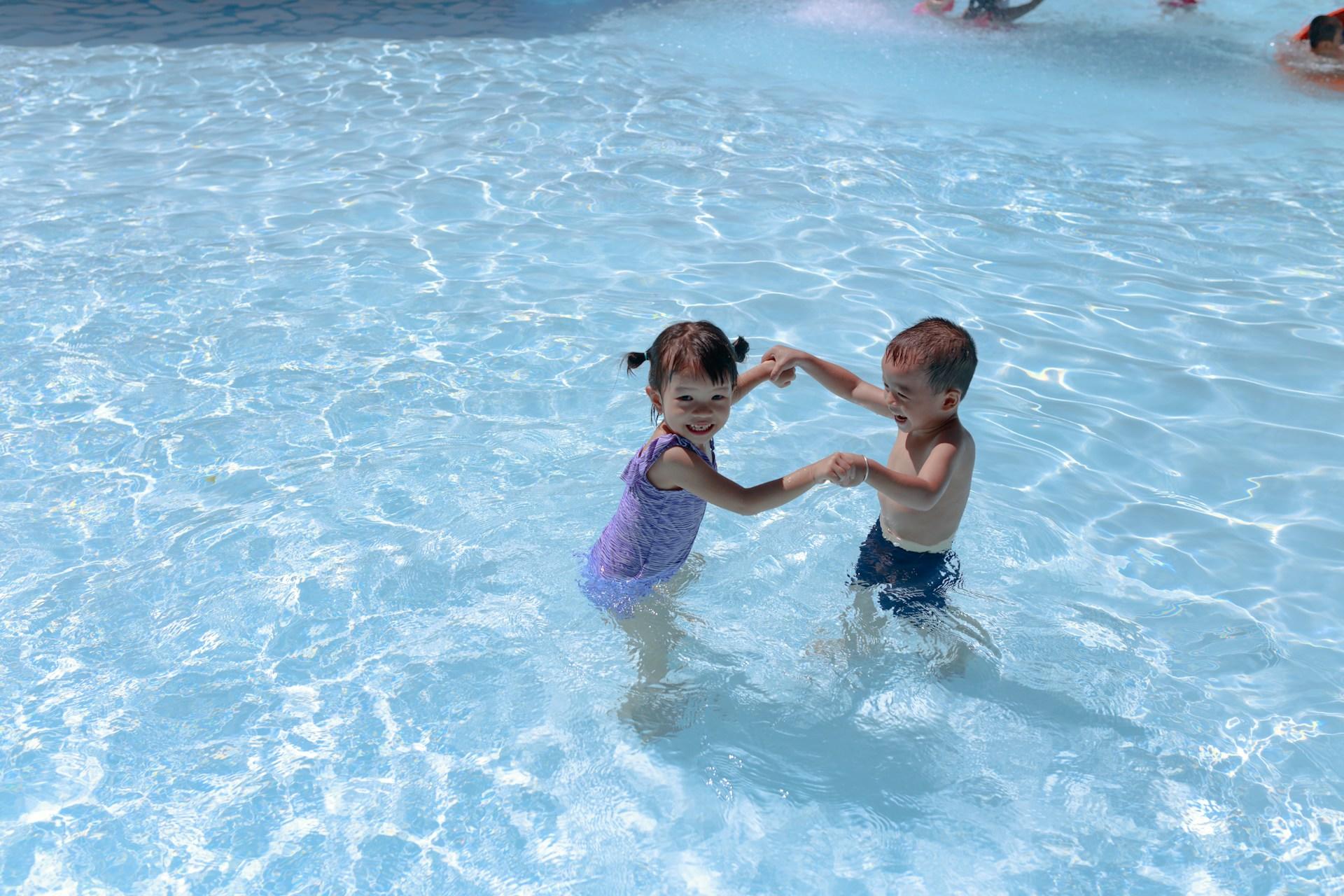 enfants bas âge jouant dans petit bassin