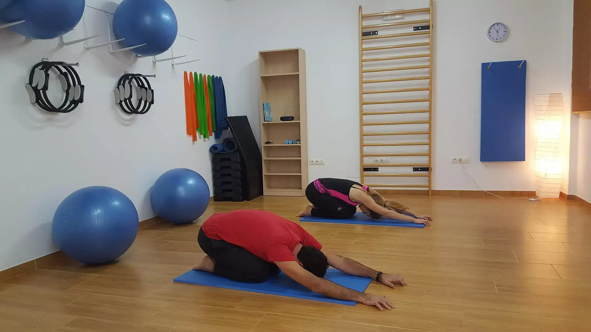 personnes pratiquant le pilates dans un studio de yoga