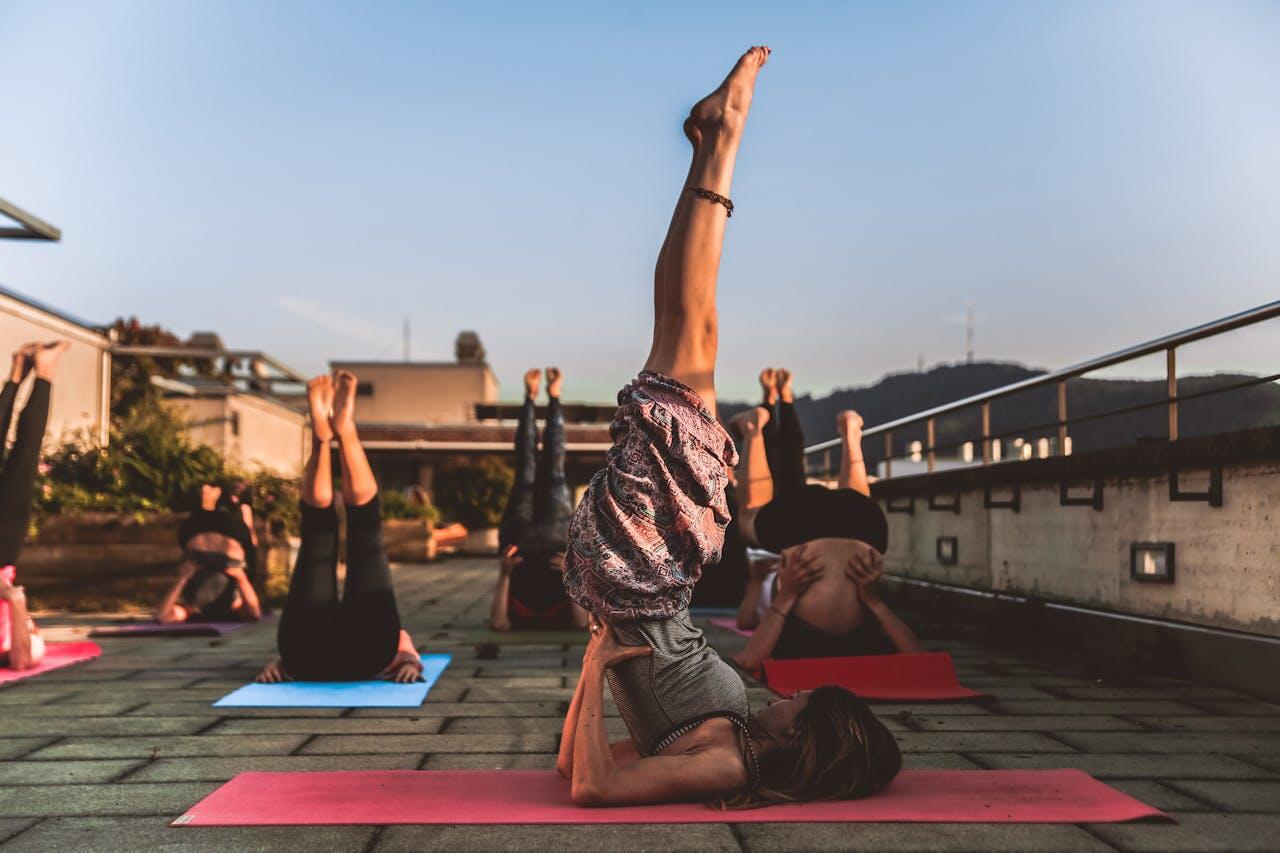 personnes faisant du yoga sur un toit terrasse