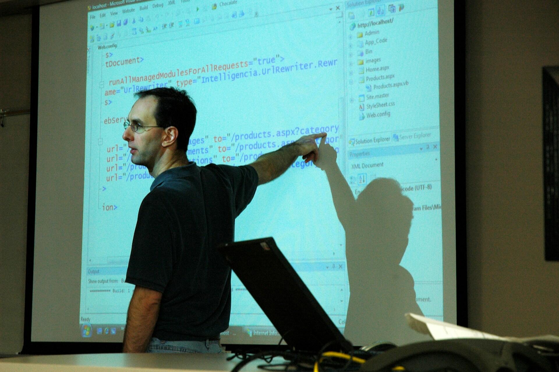 Un professeur d'informatique devant un rétroprojecteur en classe.
