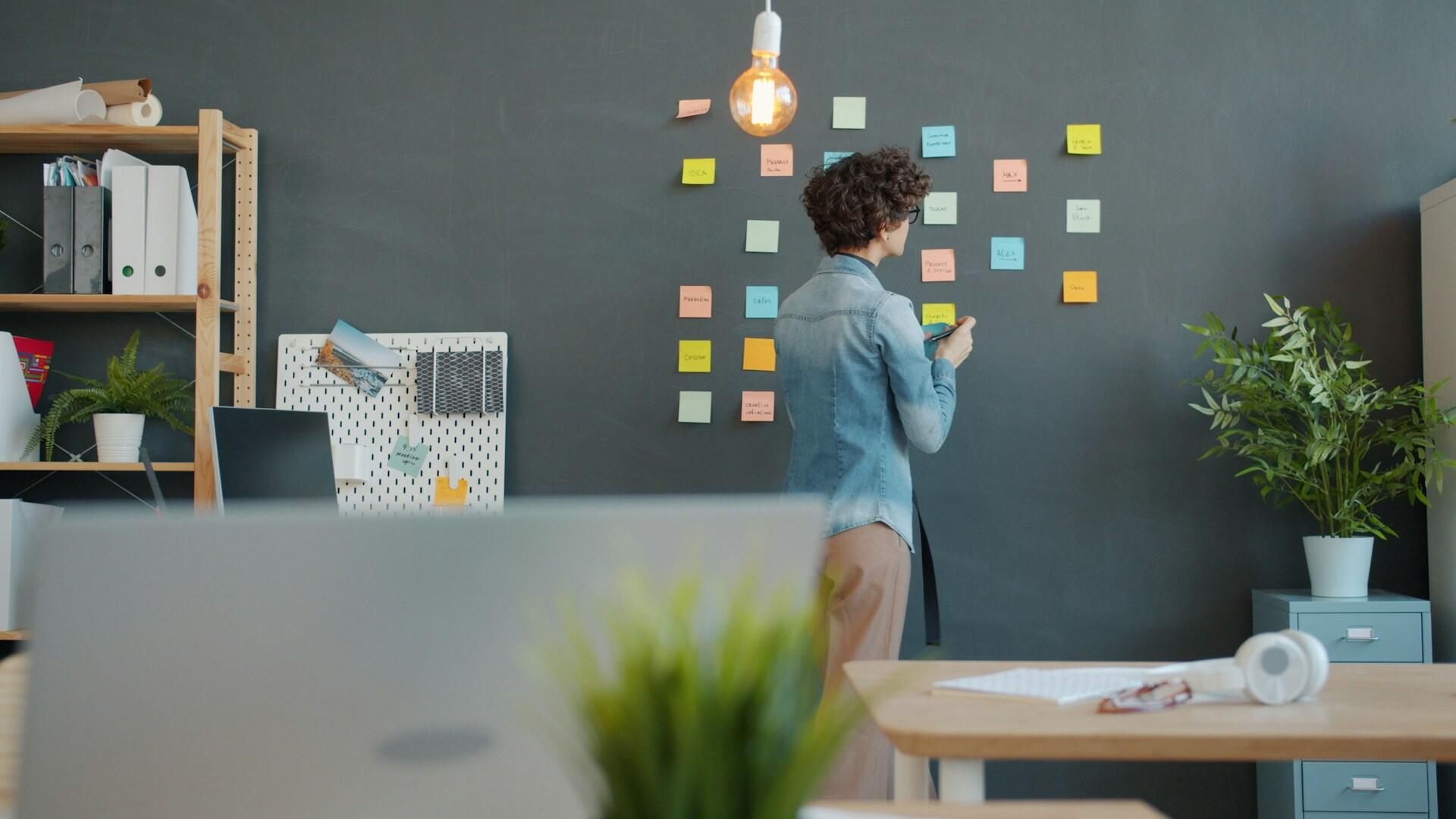 Un étudiant devant un tableau avec des notes.