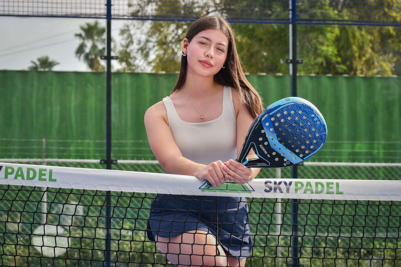 jeune femme avec raquette bleu au filet skypadel