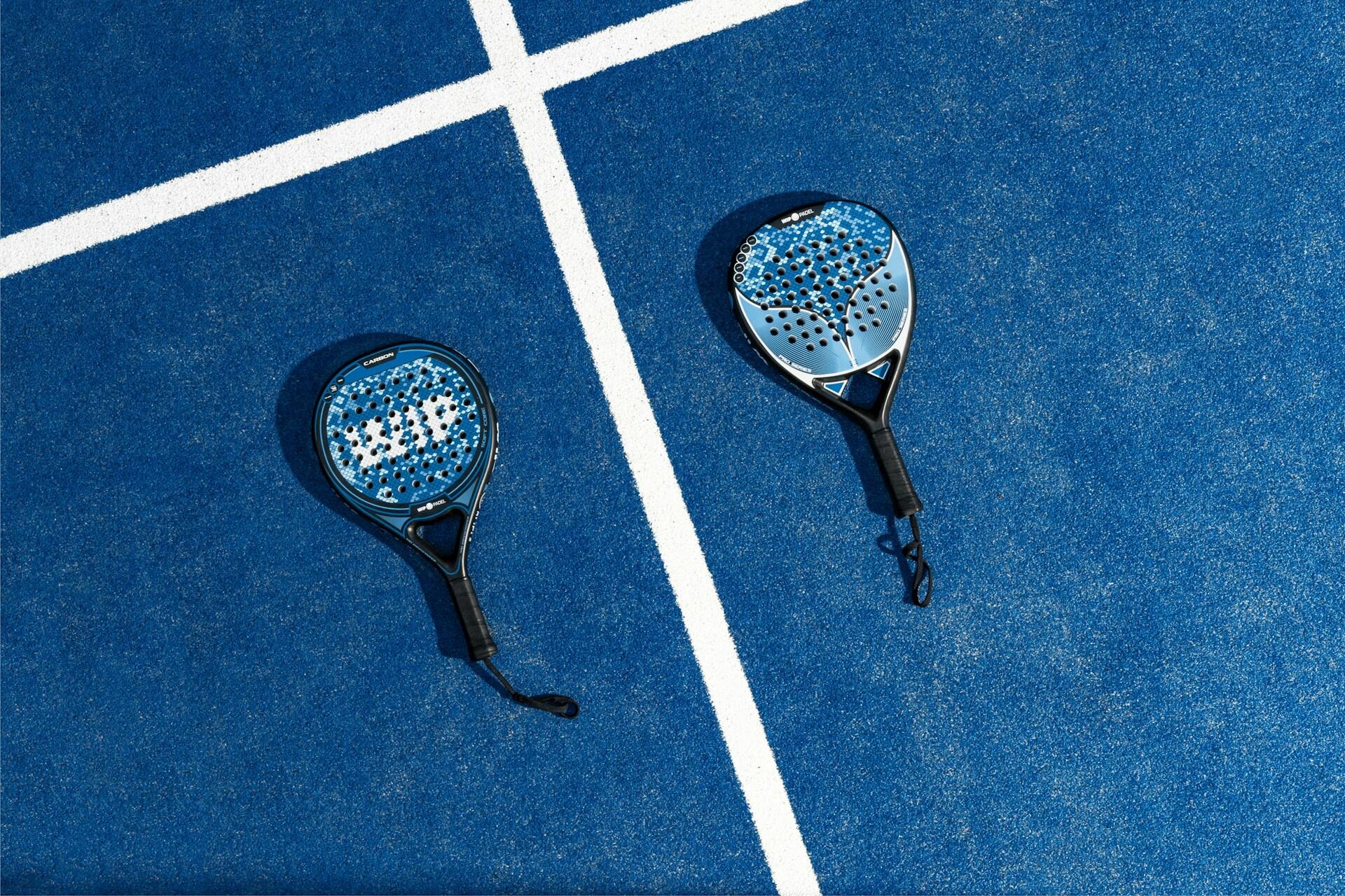 deux raquettes de padel bleues sur un terrain bleu