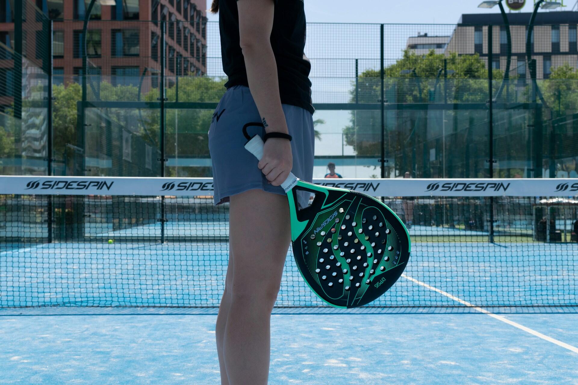 femme debout sur terrain de padel avec sa raquette
