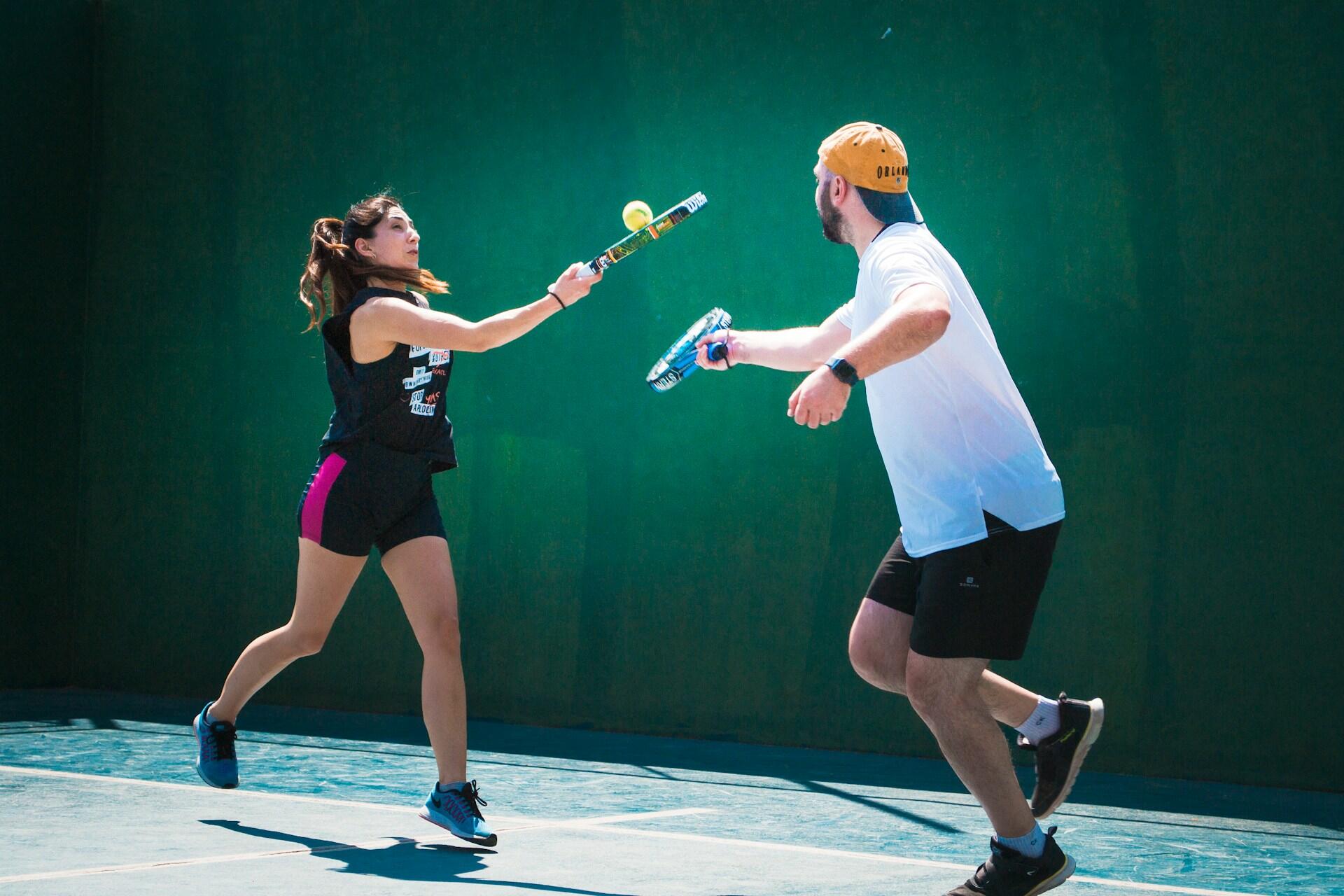 un homme et une femme au padel avec raquette et balle