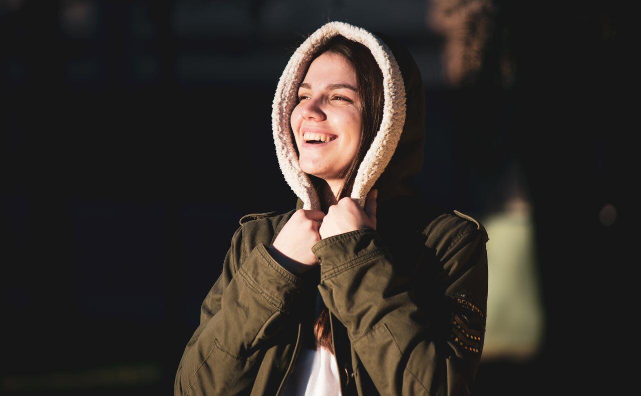 ado souriante dehors en manteau a capuche fourree