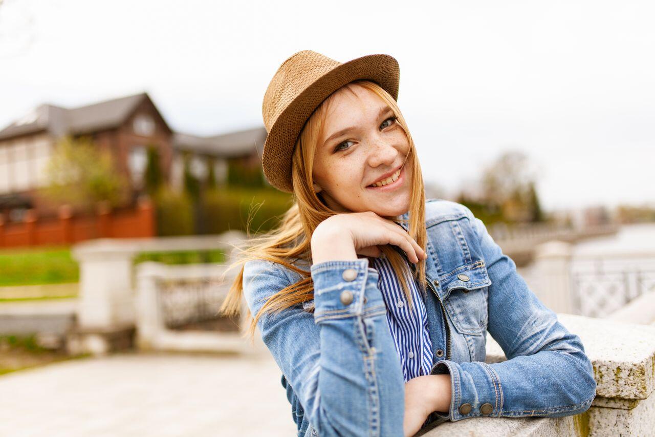 adolescente blonde avec un chapeau et une veste en jean