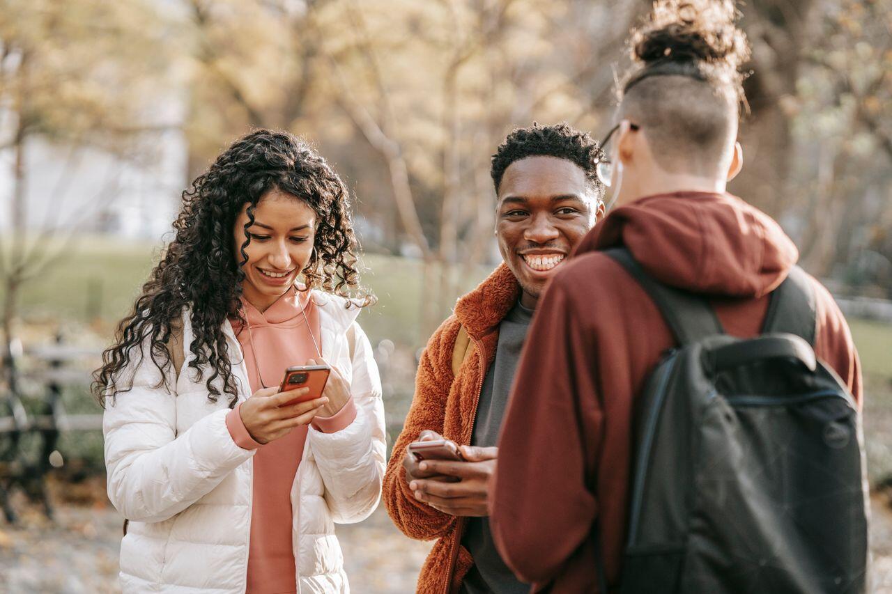 trois ados dans les bois avec leurs sac a dos souriant