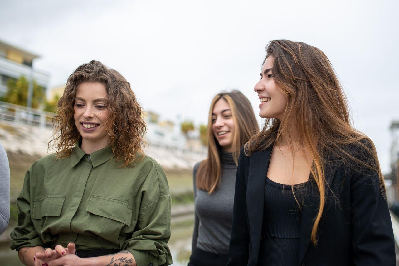 trois jeunes femmes souriant marchant a l exterieur
