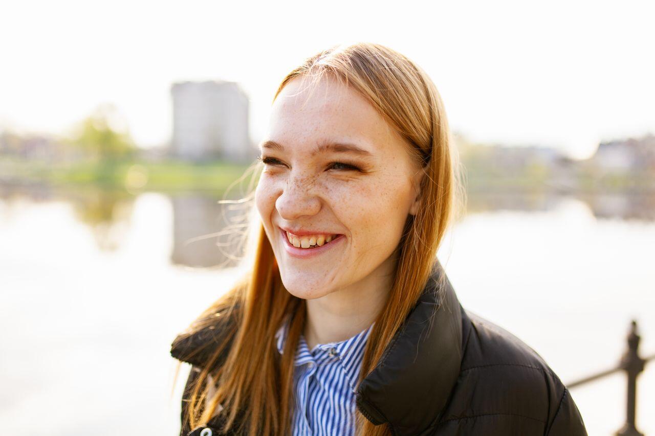 jeune ado souriante devant un lac