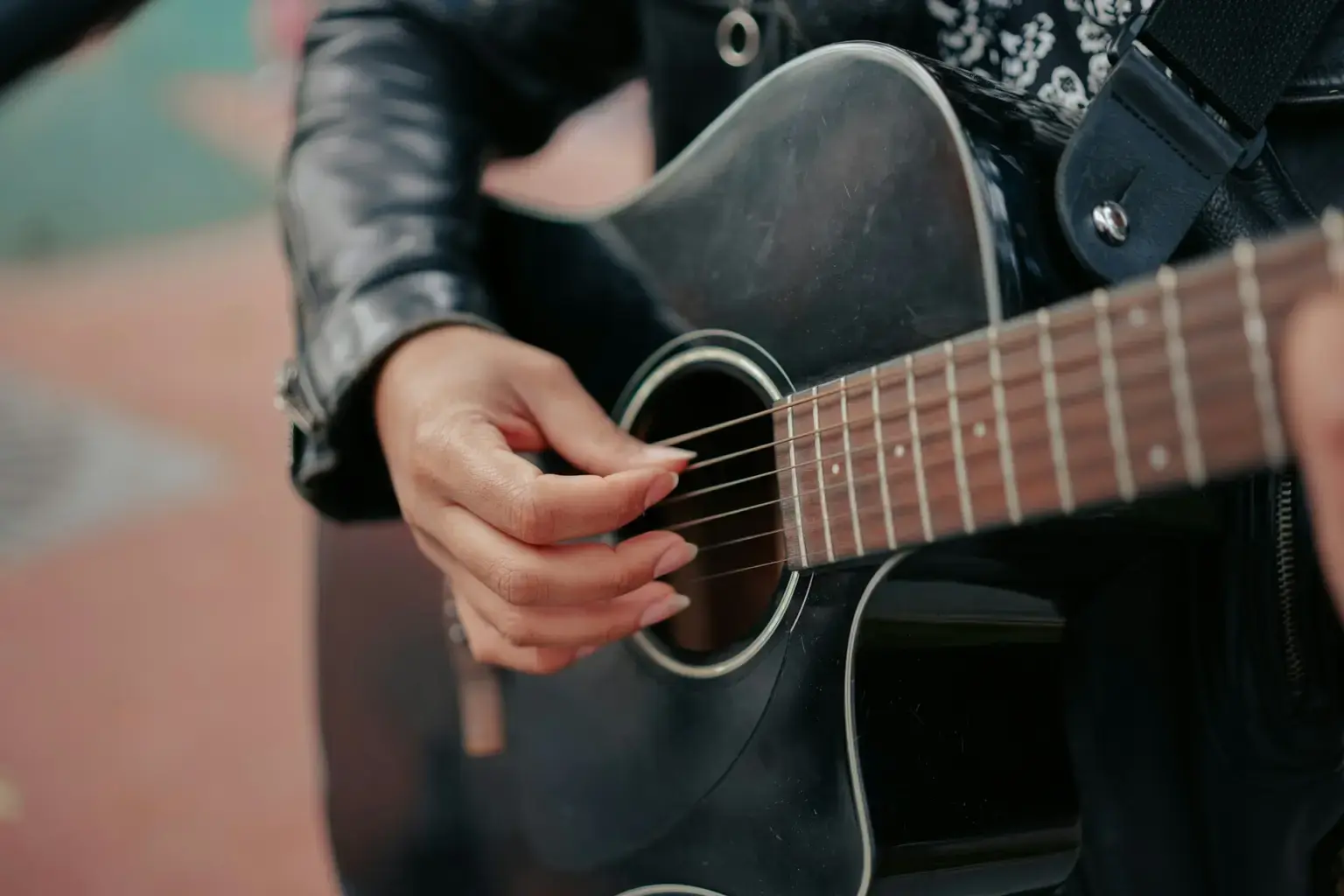 Une main qui gratte les cordes d'une guitare
