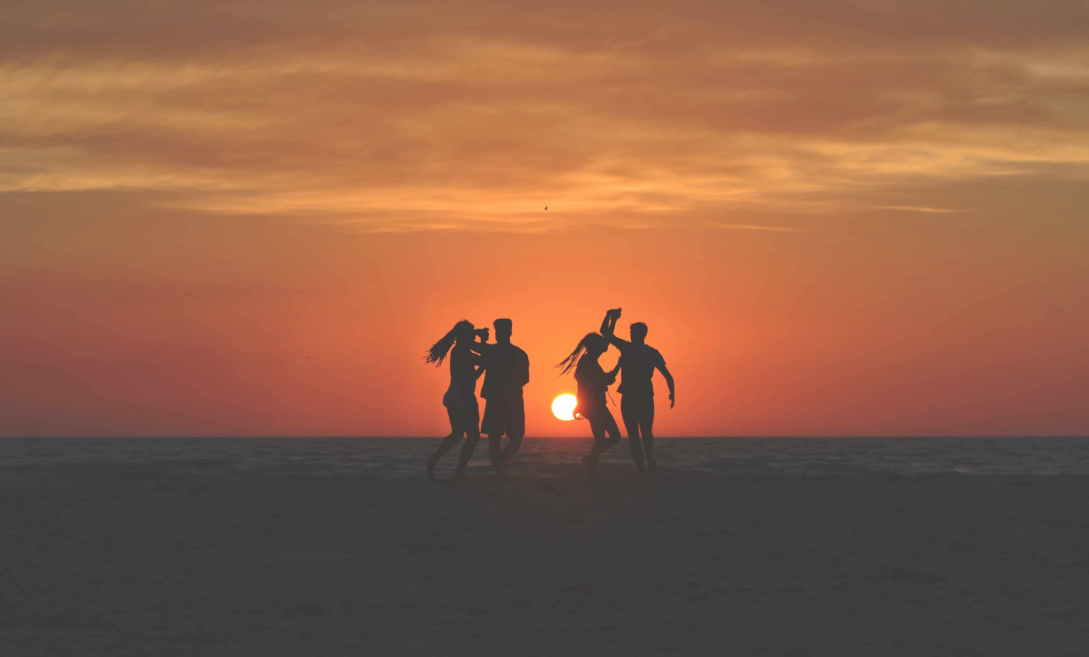 Siluetas en la playa bailando