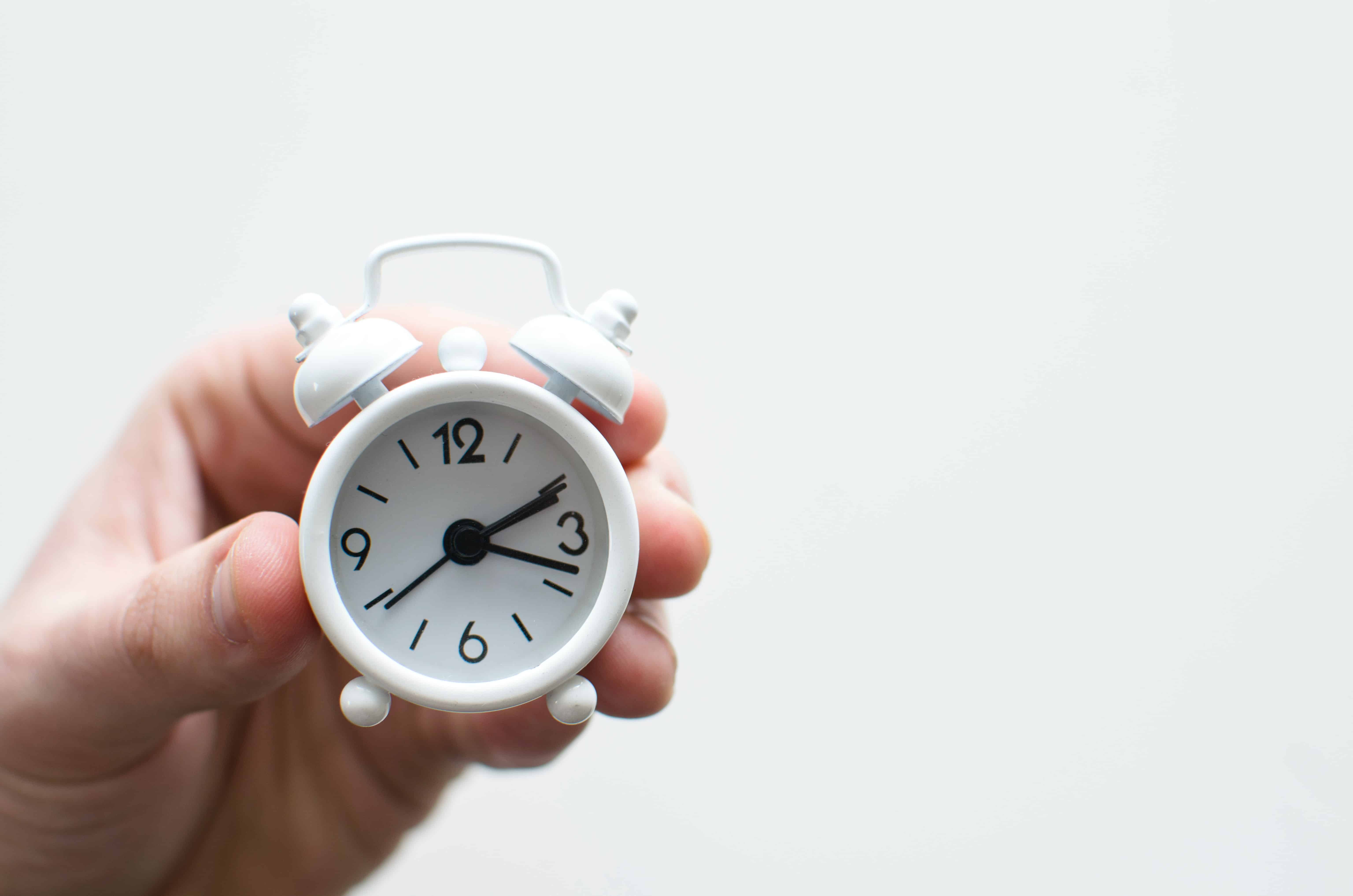 Reloj despertador en la mano