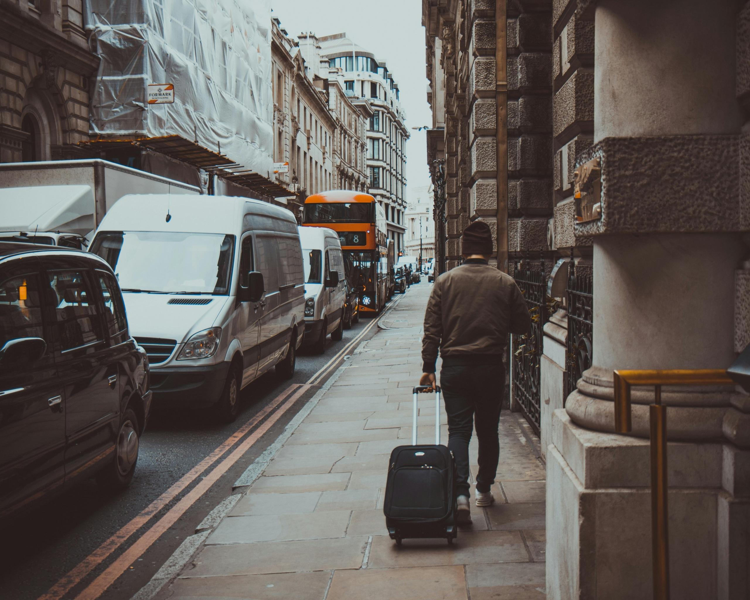 Hombre caminando con una maleta en Londres.