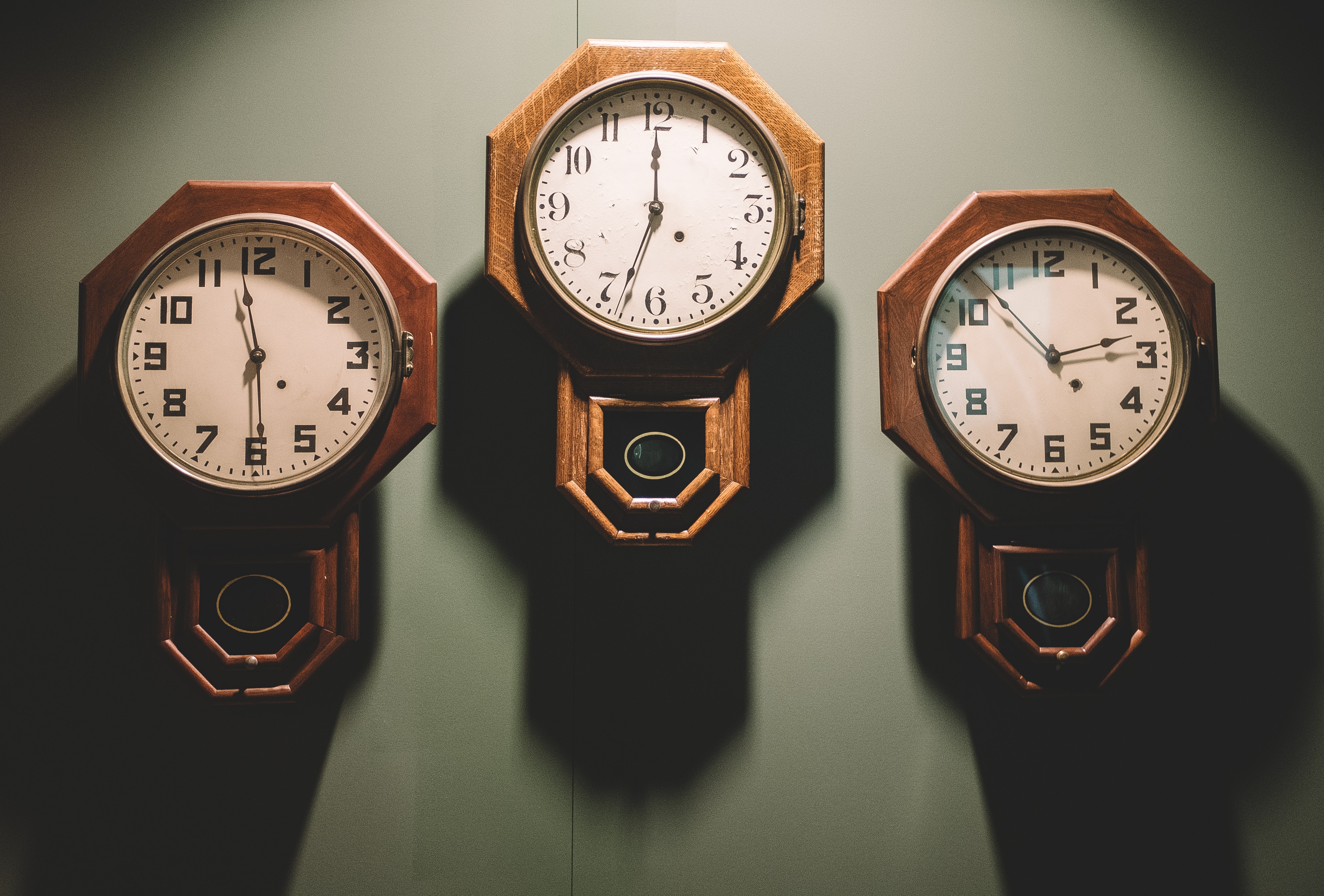 Tres relojes colgando en el muro