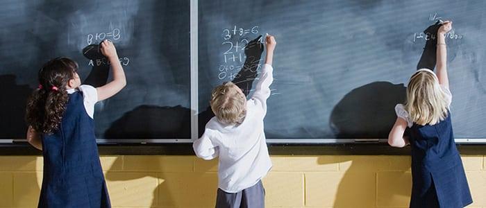 Niños escribiendo en pizarra