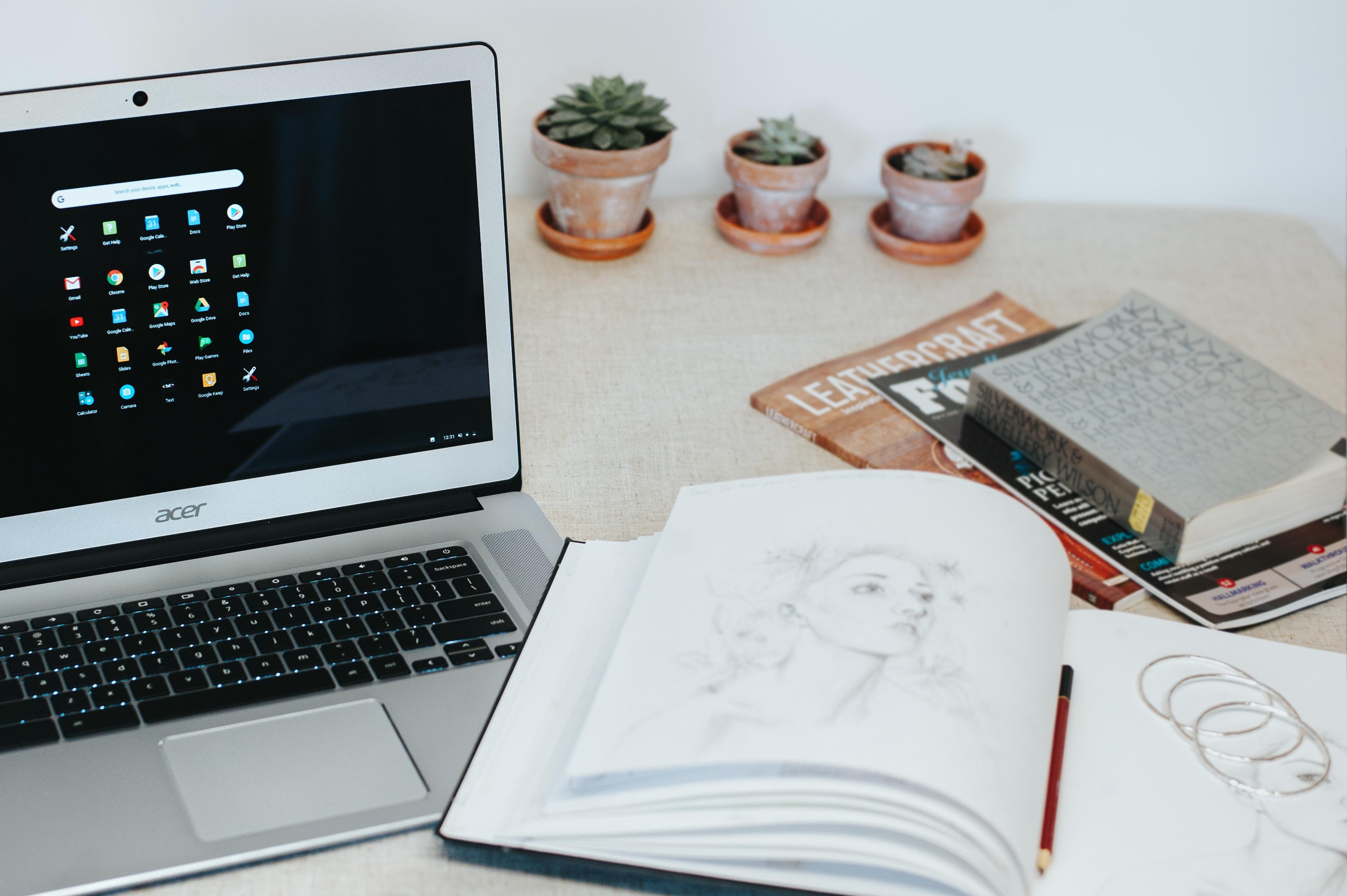 Computador, cuaderno y revistas.