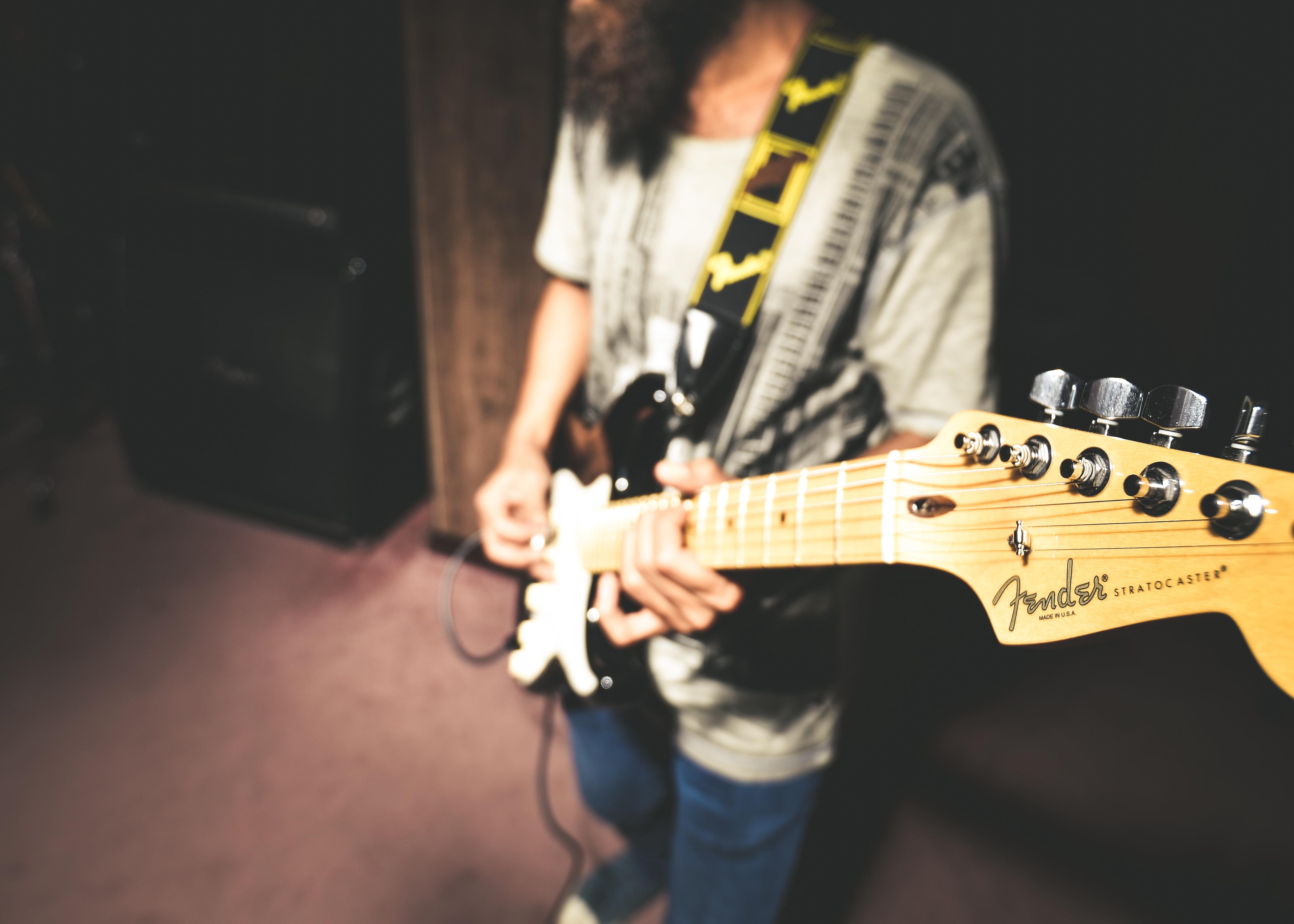 Persona toca guitarra Fender