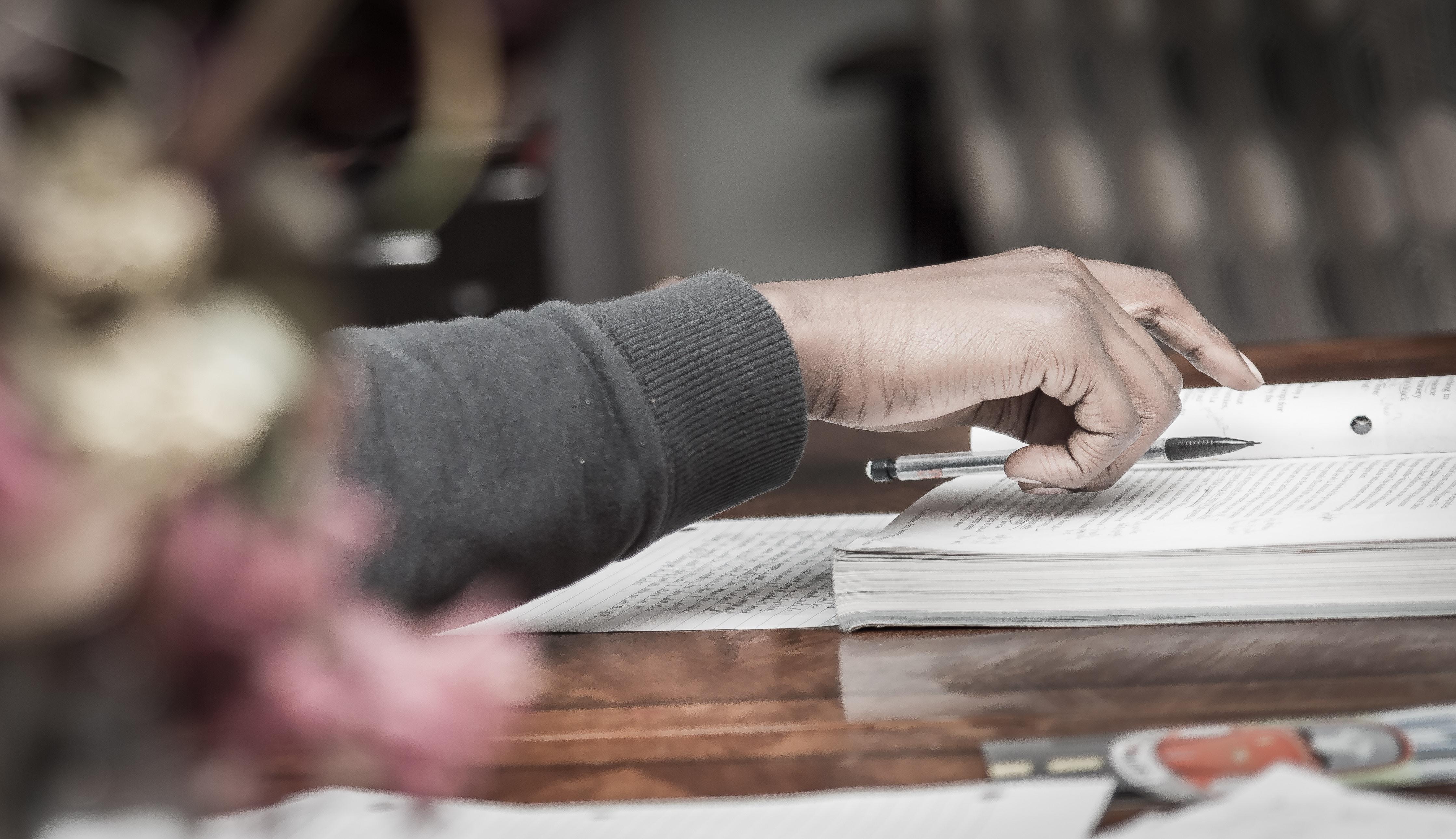 Mano sobre cuaderno y libro