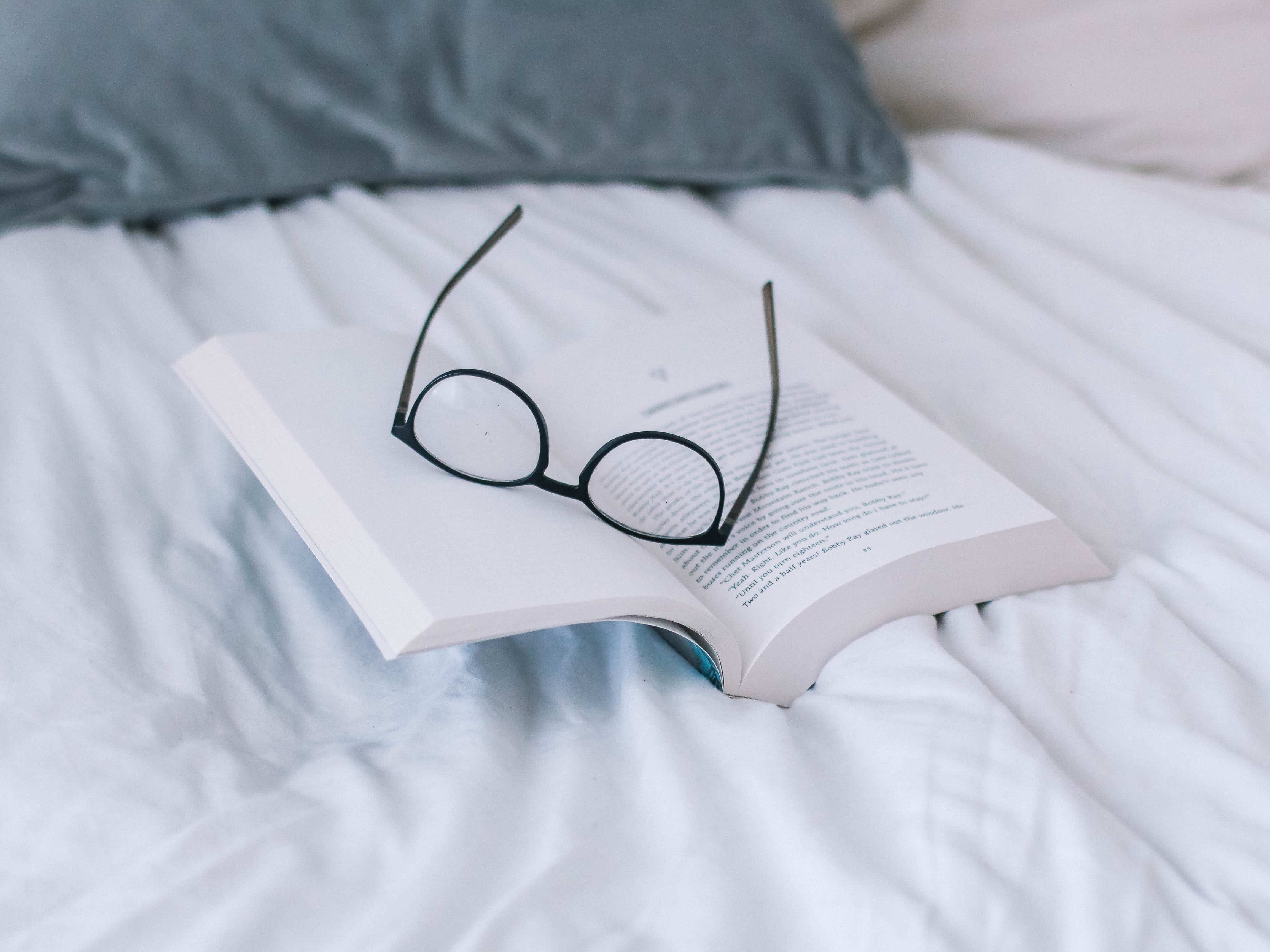 Lentes sobre libro en la cama