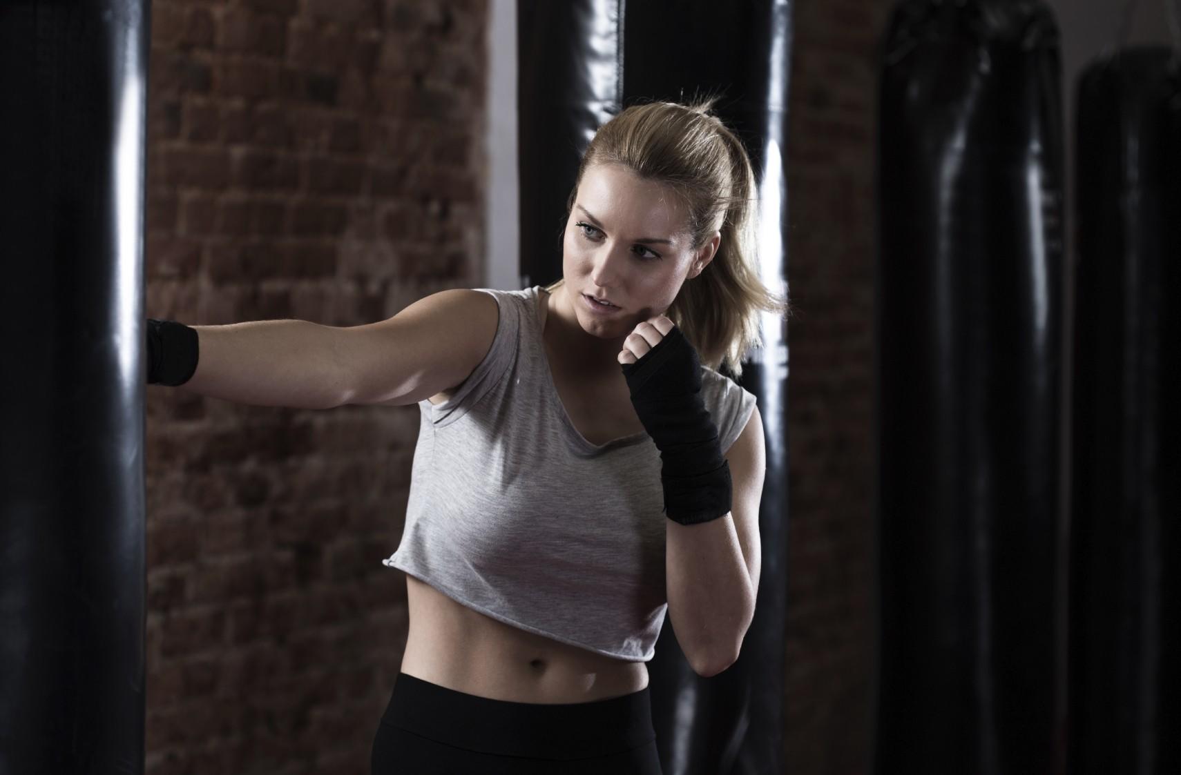Mujer pegando a saco de boxeo