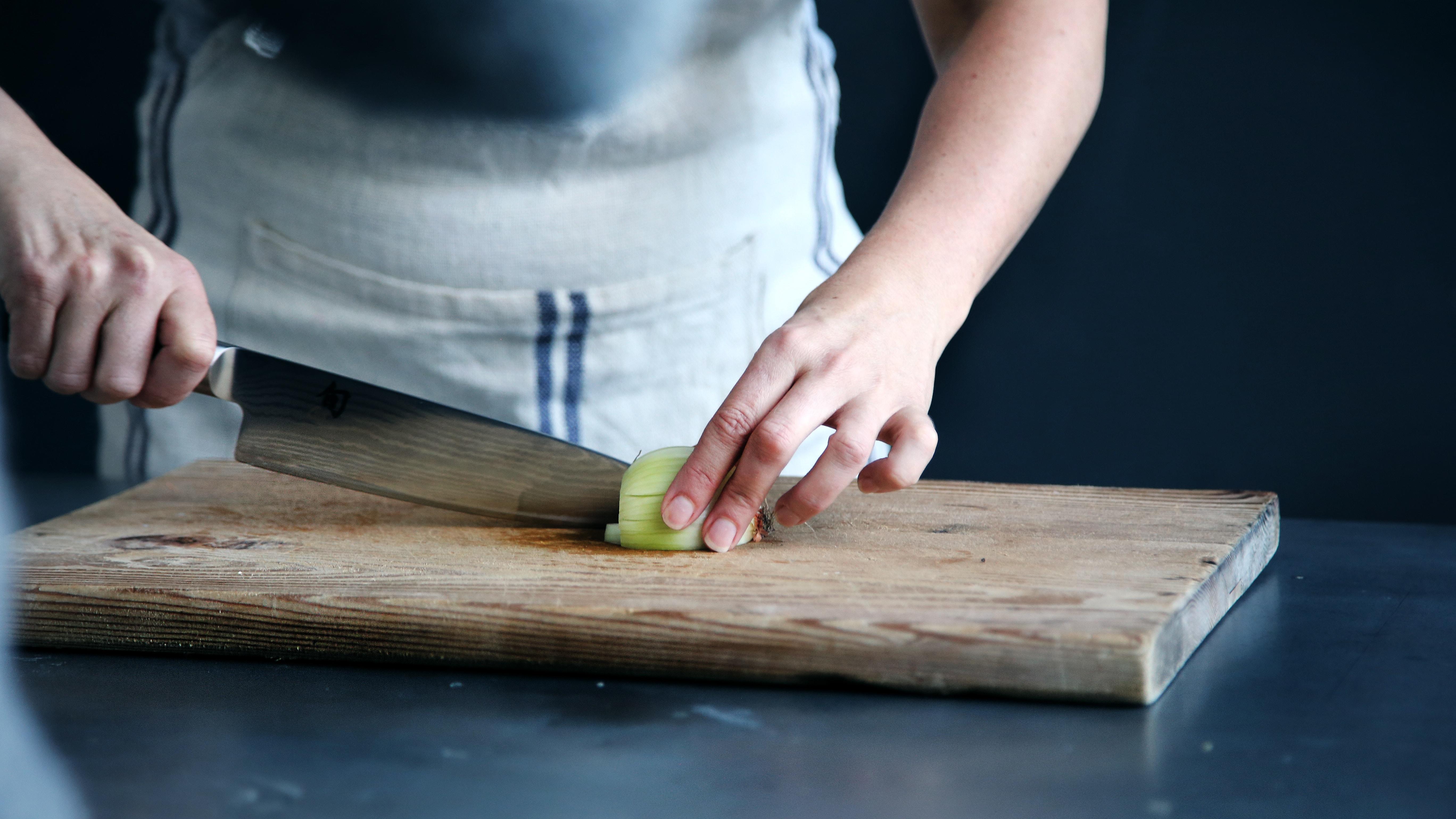 Persona cortando sobre tabla de cocina