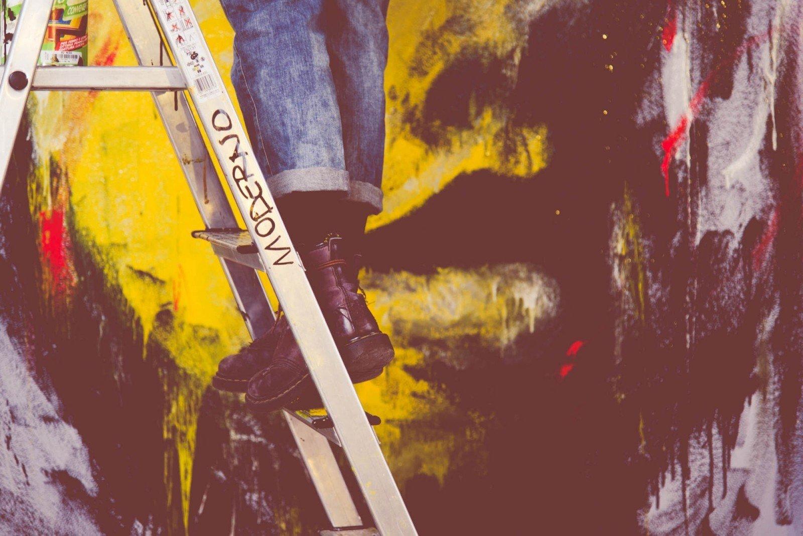 Persona en escalera haciendo un mural