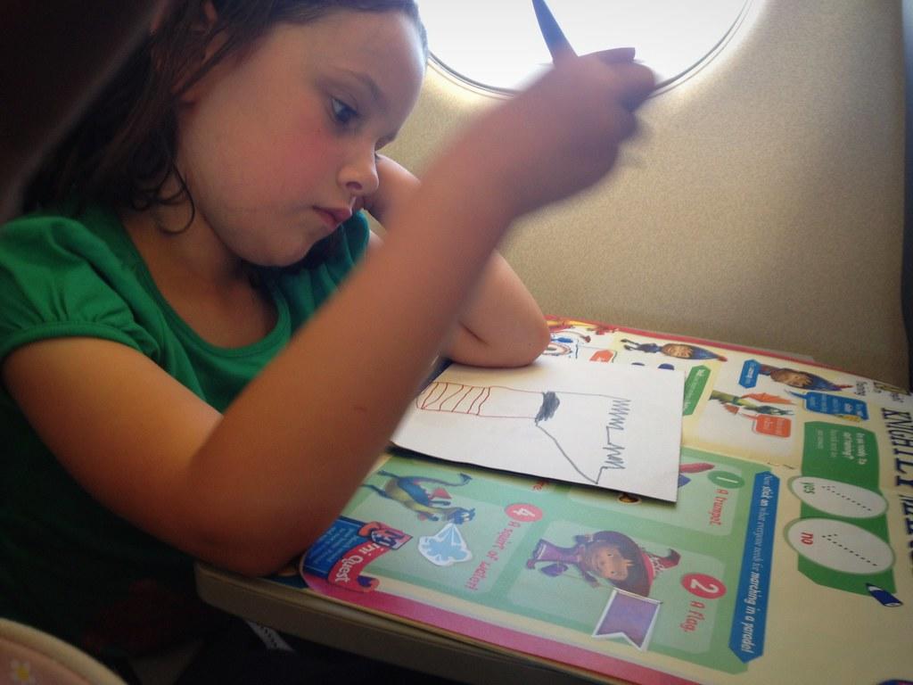Niña dibujando con libro de ejercicios