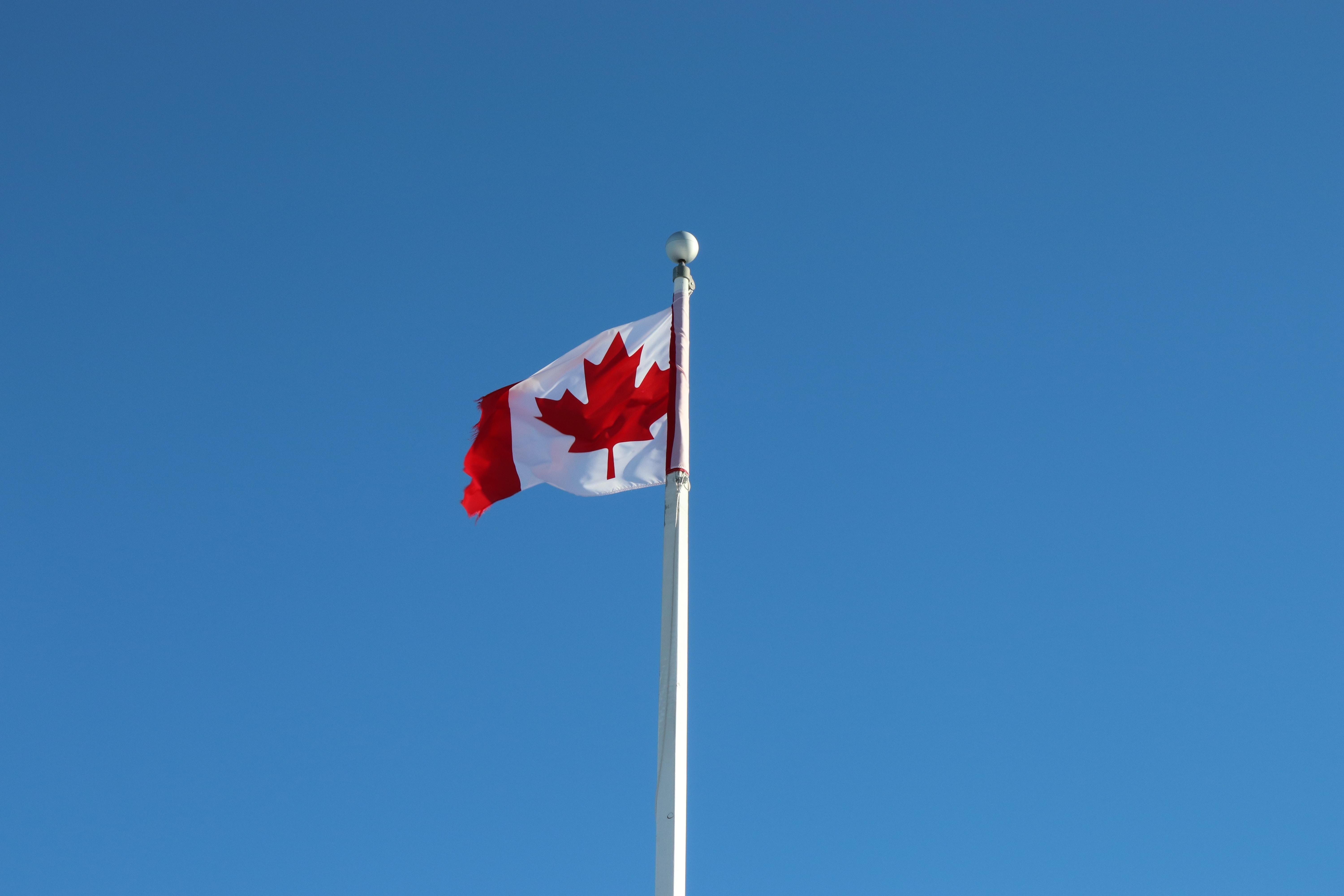 Bandera de Canadá con cielo azul