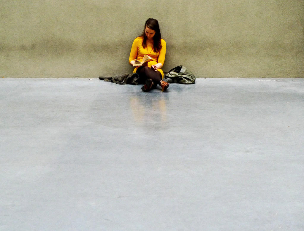 Mujer vestida de amarillo leyendo