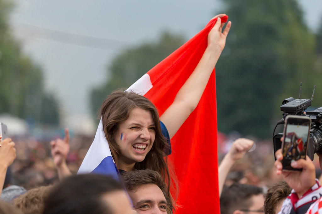 Mujer sujetando bandera francesa sobre los hombros