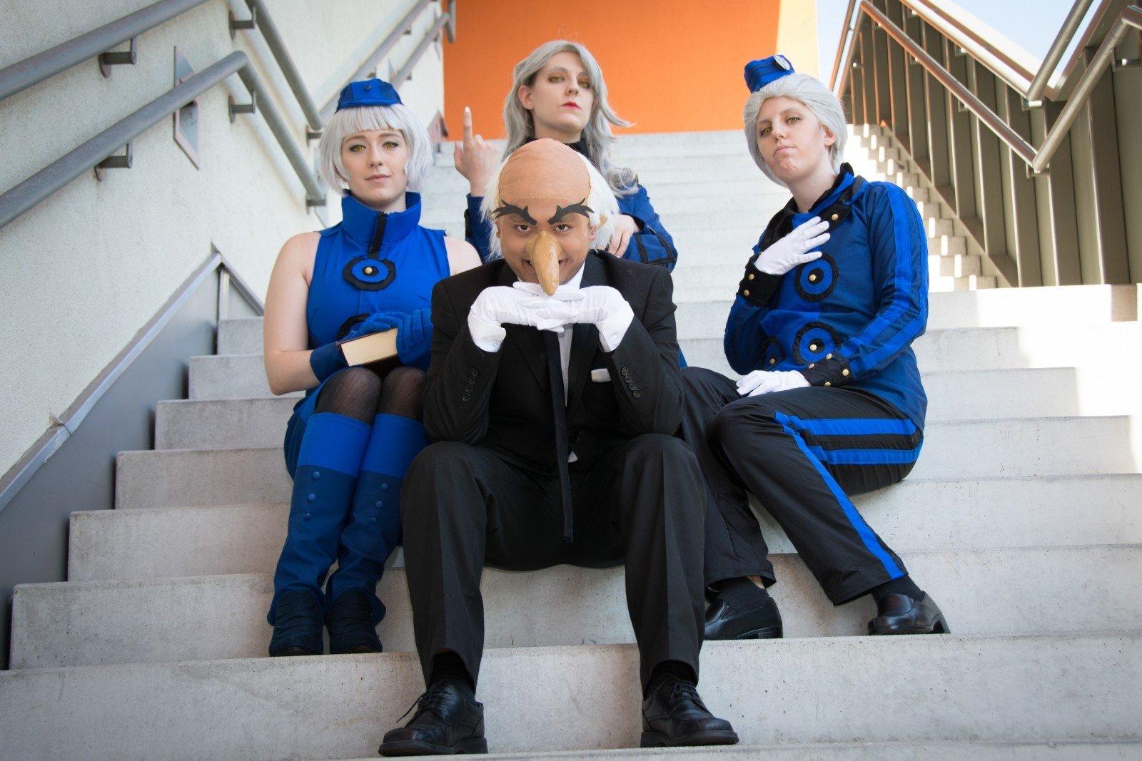 Cuatro cosplayers sentados en escalera