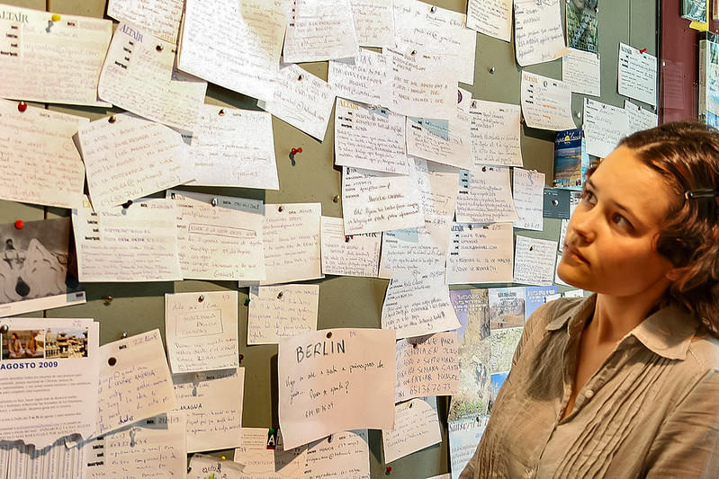 Mujer observa panel de anuncios