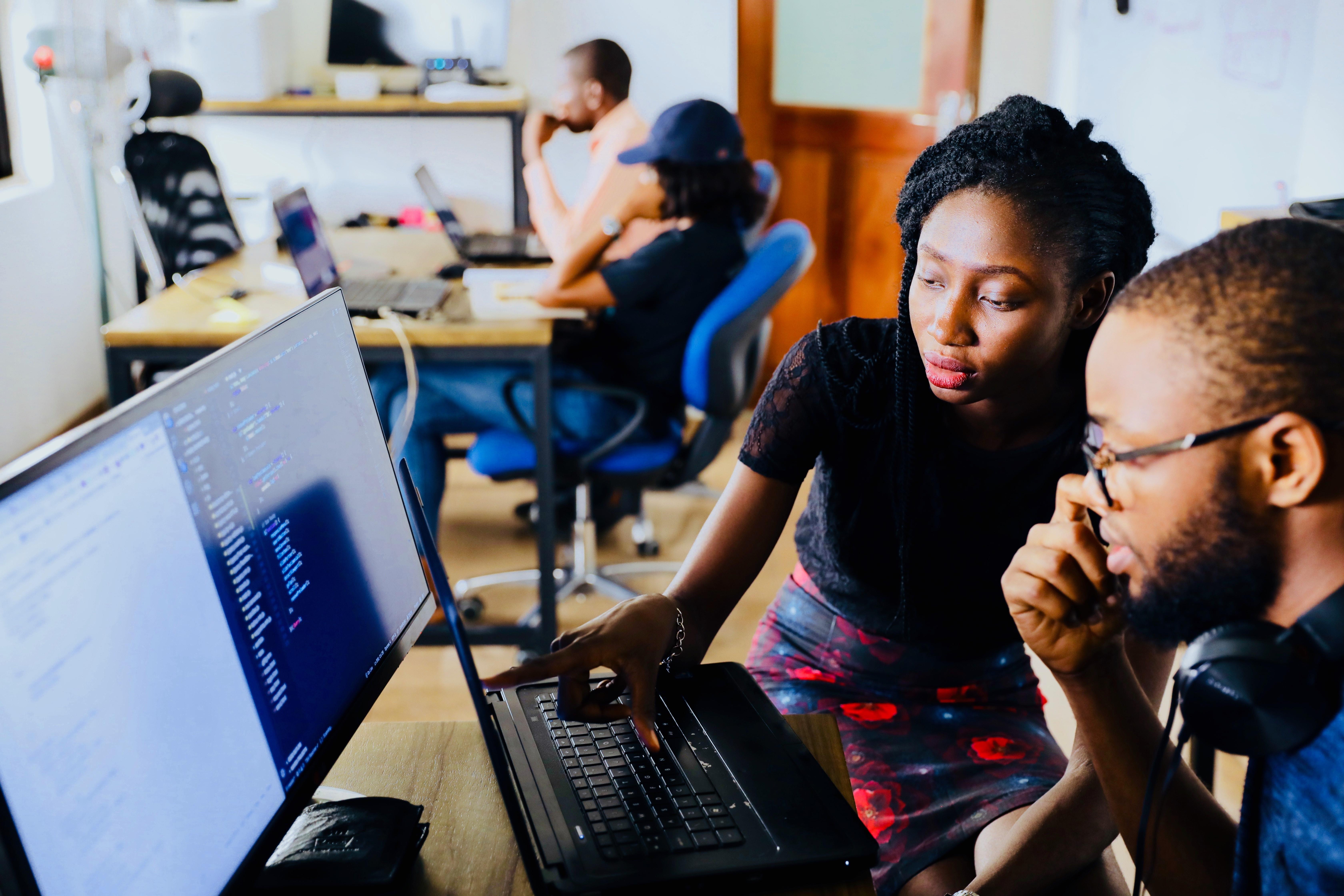 Dos aldultos trabajan juntas frente a un computador