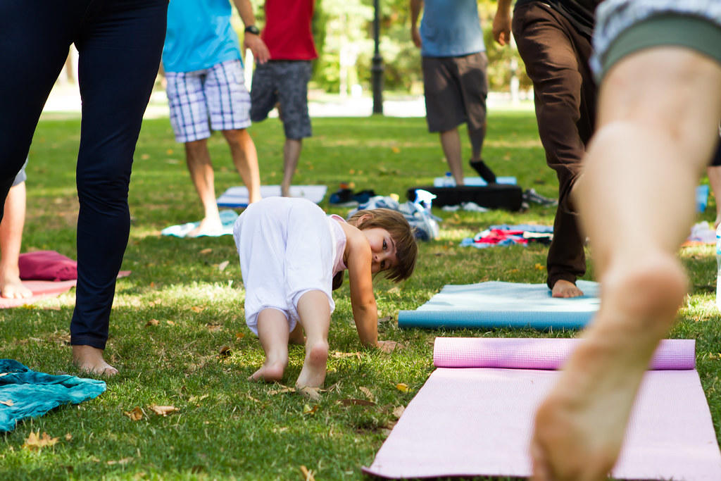 Niña hace yoga en parque